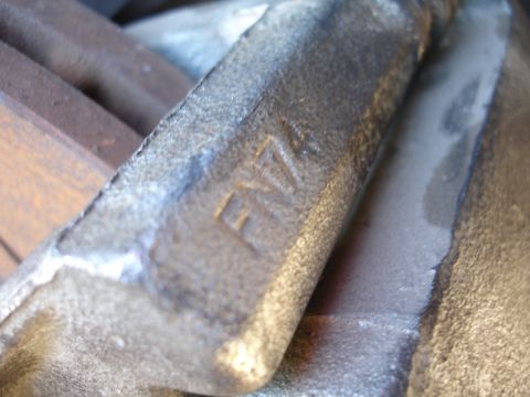 1990 Ford Taurus - Cast metal part with 'FNZ' embossed on its surface.
