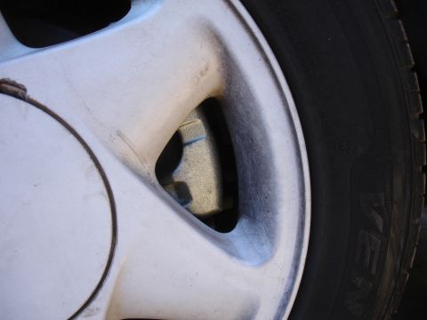 1990 Ford Taurus - Close-up of a vehicle's wheel and tire, showing the brake caliper.