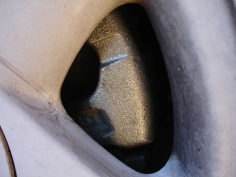 1990 Ford Taurus - A close-up view of a silver brake caliper, likely part of a front brake upgrade.