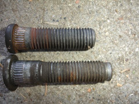 1990 Ford Taurus - Close-up view of two used wheel studs, showing wear and rust.