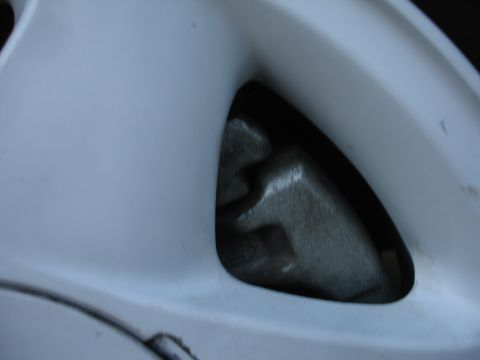 1990 Ford Taurus - Brake caliper seen through a wheel spoke.