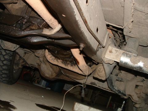 1988 Ford F-150 - The underside of a 1988 Ford F-150 reveals its frame, exhaust system, and suspension parts.