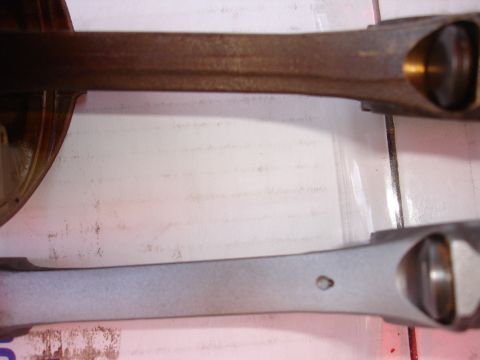 1992 Ford Taurus - Two connecting rods are shown, one in a state of heavy rust and the other appearing clean and freshly processed.