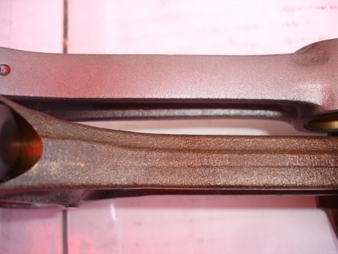1992 Ford Taurus - Close-up view of two engine connecting rods, highlighting their contrasting textures and finishes.