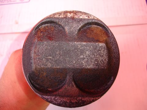 1992 Ford Taurus - A heavily used piston, likely from an engine rebuild, shows significant carbon deposits and distinct valve reliefs.
