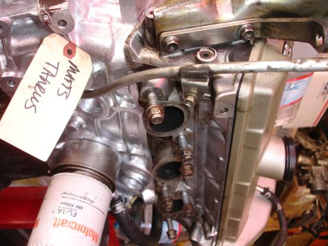 1992 Ford Taurus - Close-up of an engine block and oil filter, with a tag that may indicate the vehicle model or part number.