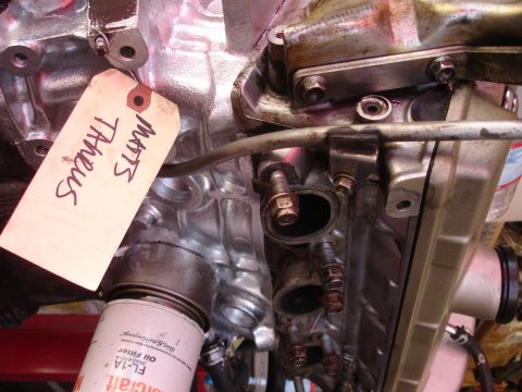 1992 Ford Taurus - Close-up of an engine block with an oil filter and a handwritten tag.