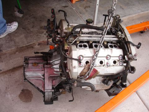 1992 Ford Taurus - Engine and transmission assembly suspended by chains, ready for installation or removal.