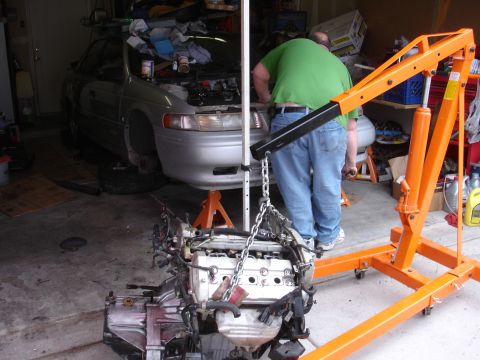 1992 Ford Taurus - Engine removal in progress for a 1992 Ford Taurus, with the engine suspended by an engine hoist.