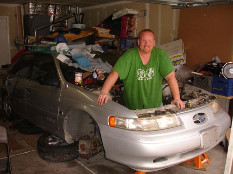 1992 Ford Taurus - A silver sedan, likely a Ford Taurus from the mid-1990s, is parked in a garage with its front end disassembled.