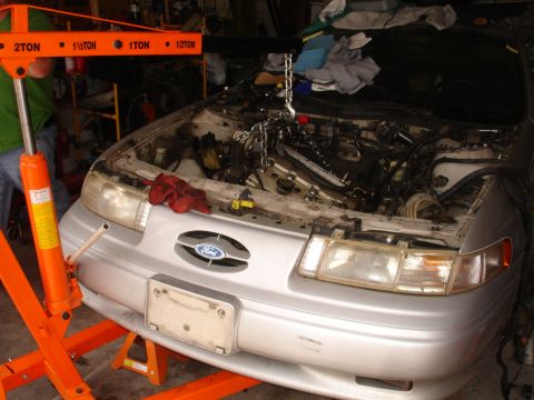 1992 Ford Taurus - Engine hoist is attached to the engine of a 1992 Ford Taurus in a garage.