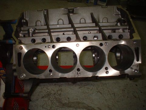 1968 Ford Galaxie - Engine block with four cylinders visible, resting on a stand. Text on a nearby jack reads '450 POUND'.