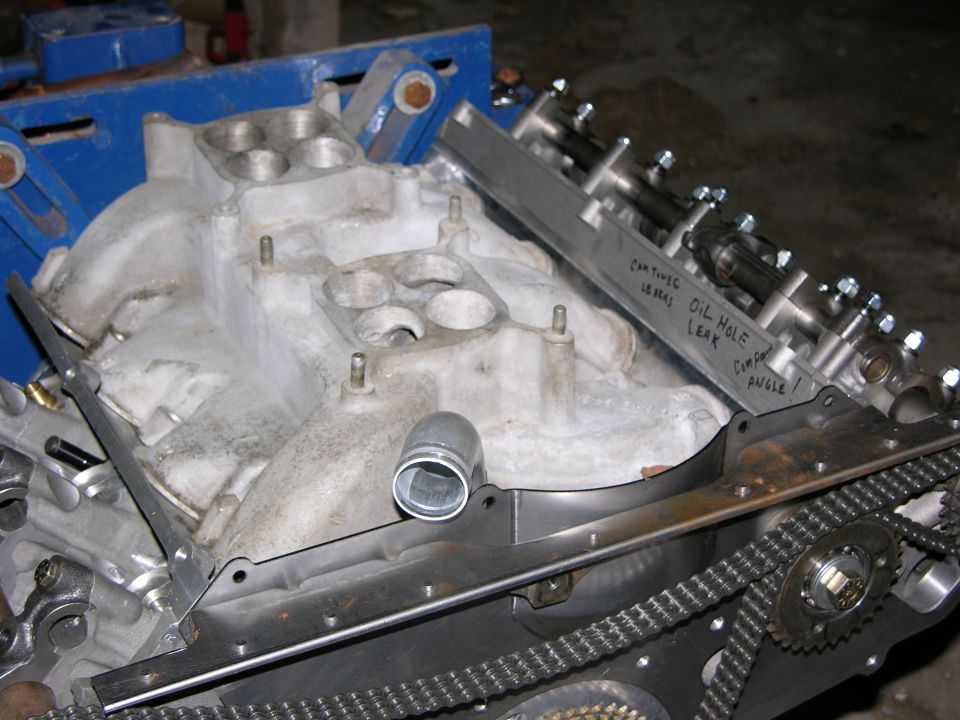 Aluminum intake manifold and cylinder head with timing chain guides marked in marker noting oil leaks