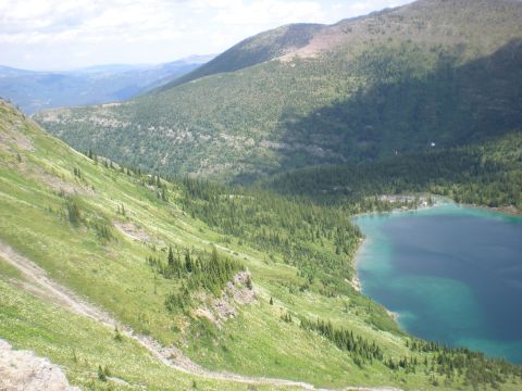 1974 Ford Ranchero - A scenic view of a mountain range overlooking a clear blue lake, with lush green vegetation covering the slopes.
