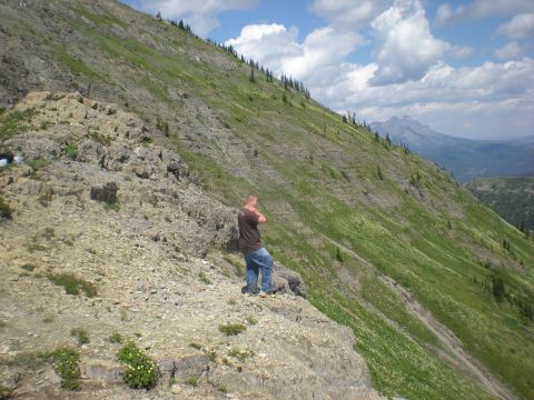 1974 Ford Ranchero - Man surveys the mountain landscape from a rocky ledge.