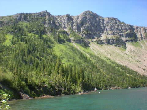 1974 Ford Ranchero - A scenic view of a mountain range covered in trees, with a clear blue lake in the foreground.