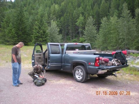 1974 Ford Ranchero - A dark blue pickup truck is parked with its doors and tailgate open, loaded with camping gear.