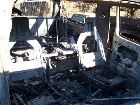 1977 Ford F-150 - The interior of a severely damaged vehicle, with extensive fire and smoke damage visible throughout.