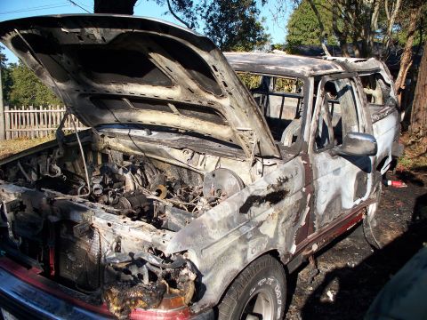 1977 Ford F-150 - This severely damaged pickup truck shows extensive fire damage to the engine bay and cab.