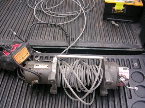 1990 Ford Bronco - A winch and a car battery are placed in the bed of a truck.