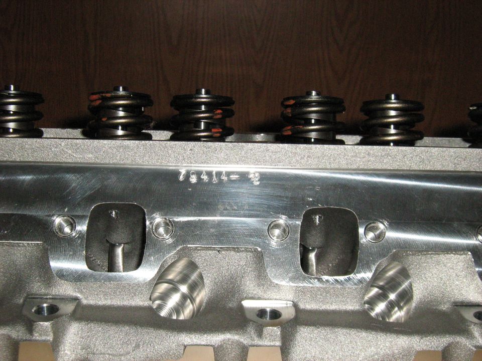 Close-up of an engine cylinder head with valve springs visible. Part number 75414-2 is stamped on the metal