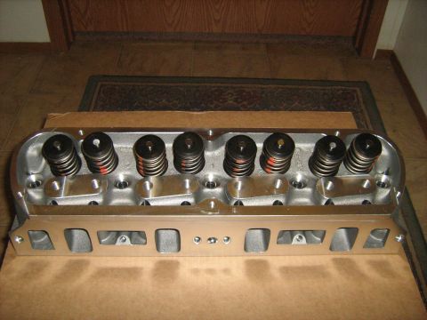 1988 Mercury Grand Marquis - An engine cylinder head with visible valve springs and retainers is presented on a cardboard surface.