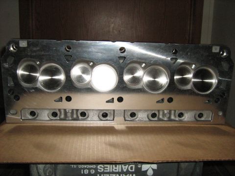 1988 Mercury Grand Marquis - A close-up view of a polished aluminum engine cylinder head, resting on a cardboard box.