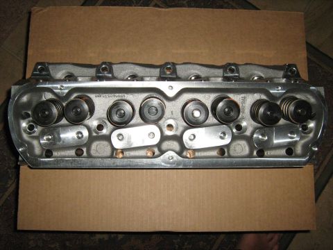 1988 Mercury Grand Marquis - Close-up view of an engine cylinder head, showing valves and springs, resting on a cardboard surface.