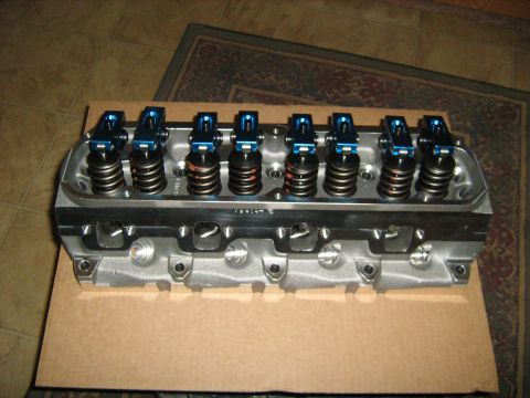 1988 Mercury Grand Marquis - An engine cylinder head with blue roller rockers and springs sits on a cardboard base.