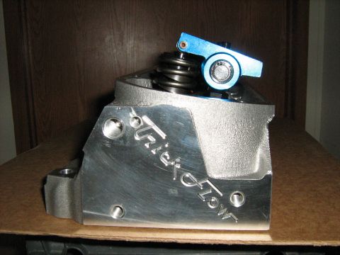 1988 Mercury Grand Marquis - A close-up view of an aftermarket aluminum engine cylinder head with visible branding and valve train components.