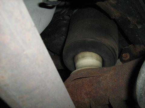 1988 Mercury Grand Marquis - A close-up view shows a rubber suspension bellows positioned above a rusty metal component, with other vehicle parts visible.