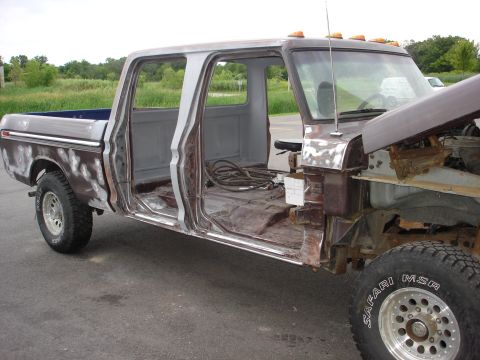 1979 Ford F-250 - This stripped-down Ford truck body is undergoing preparation for a new paint job, with its hood open revealing the engine compartment.