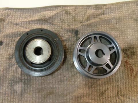 1998 Subaru Legacy - A comparison of a used pulley and a new pulley is shown on a textured cloth background.