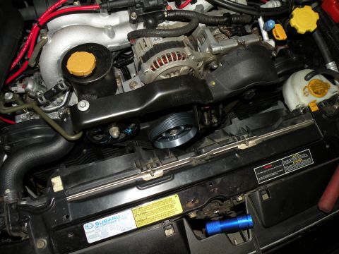 1998 Subaru Legacy - Close-up view of a vehicle's engine bay, showing various components like the alternator and fan.