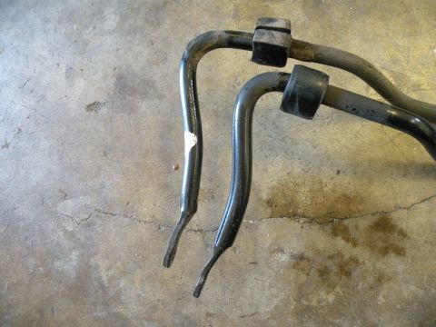 1998 Subaru Legacy - Two black sway bars with rubber bushings are shown on a concrete floor.