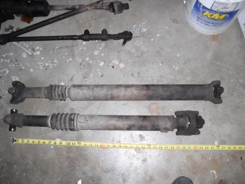 1991 Ford Bronco - Two driveshafts are shown on a concrete surface, with a tape measure indicating their lengths.