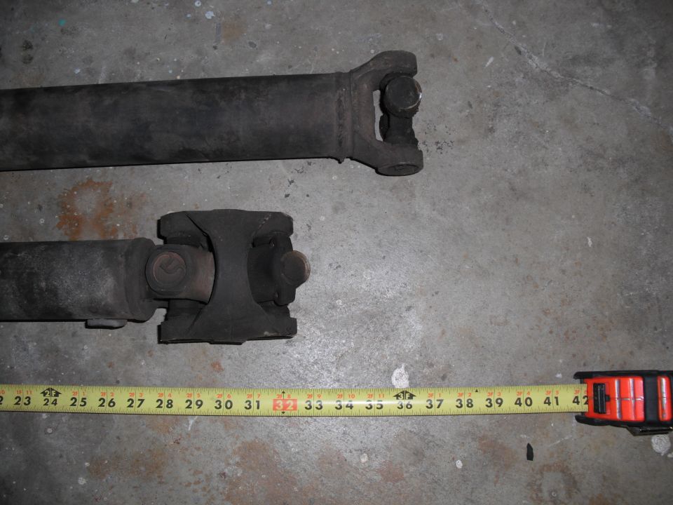 Two driveshafts with a tape measure showing lengths up to 42 inches