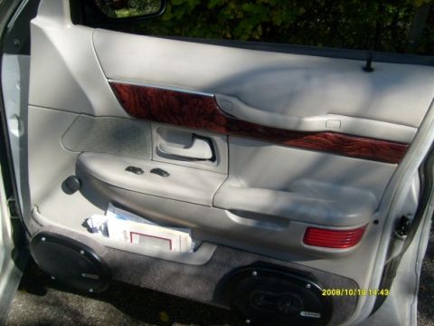 2000 Mercury Grand Marquis - The interior door panel of a 2000 Mercury Grand Marquis shows wood trim and power controls.