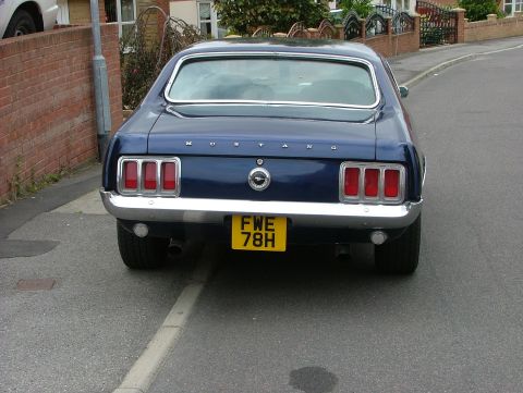 1970 Ford Mustang - Rear view of a dark blue 1969 Ford Mustang parked on a street.
