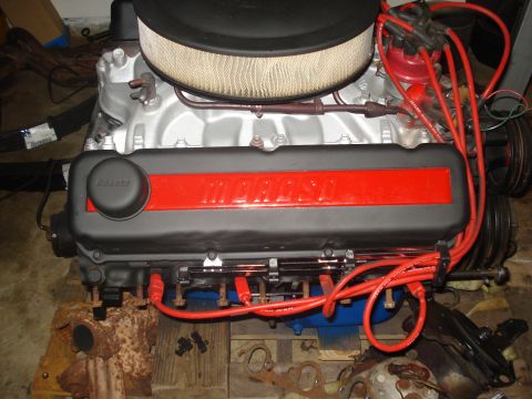 1978 Ford Bronco - Engine with Maroso valve covers and red spark plug wires sits on wooden blocks.