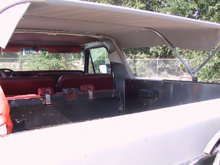 White soft top vehicle interior with red seats and black cargo area