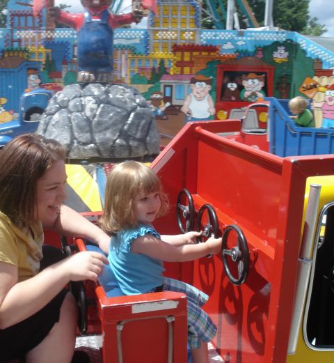 2000 Ford Crown Victoria - Children enjoy a ride at an amusement park, interacting with the vehicle's steering wheels.