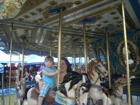 2000 Ford Crown Victoria - A mother and child enjoy a ride on a carousel at a funfair.