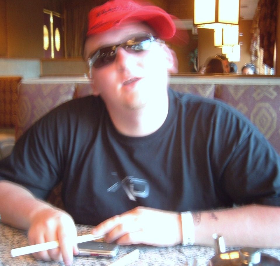 Person in red bandana and sunglasses at a table with chopsticks