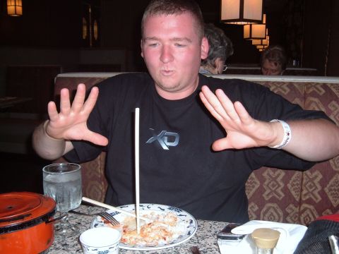 2006 Ford E350 - Man makes a gesture with his hands while sitting at a table with food in a restaurant.
