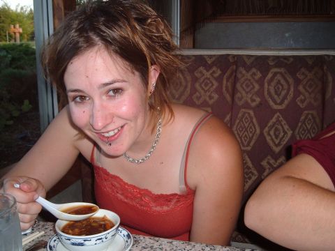 2006 Ford E350 - A woman smiles while eating soup from a bowl with a spoon.