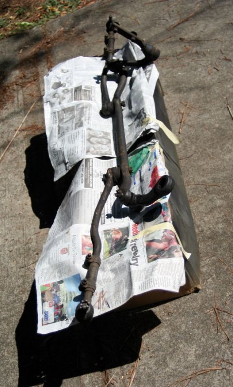 1976 Ford Ranchero - This steering linkage assembly is laid out on top of newspapers, possibly for protection or cleaning.