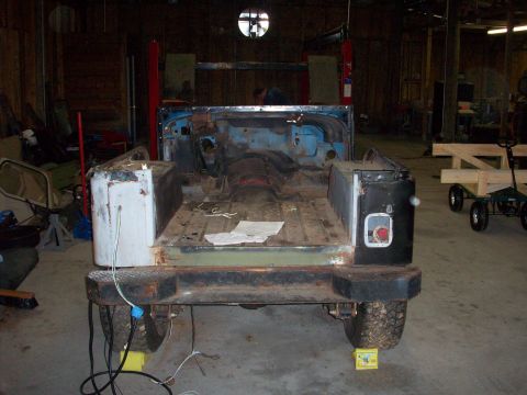 1978 Jeep CJ5 - The rear of a disassembled Jeep CJ sits in a garage, undergoing repairs or restoration.