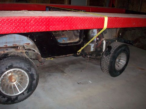 1978 Jeep CJ5 - Side view of a 1978 Jeep CJ5 body and wheels secured to a red platform.