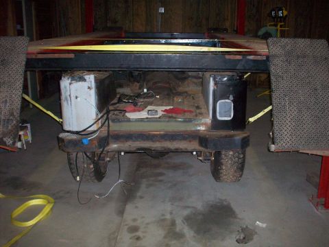 1978 Jeep CJ5 - The rear of a 1978 Jeep CJ5 is shown on a lift, with its chassis exposed and some wiring visible.